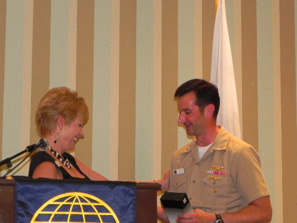 Rear Adm. Christian Becker, USN, shakes hands with Shirley Adams, chapter vice president for programs, following the admiral's speech at the July meeting.